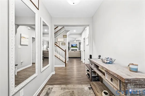 a hallway with white cabinets and wooden floor