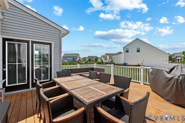 a view of a patio with table and chairs with wooden floor and fence