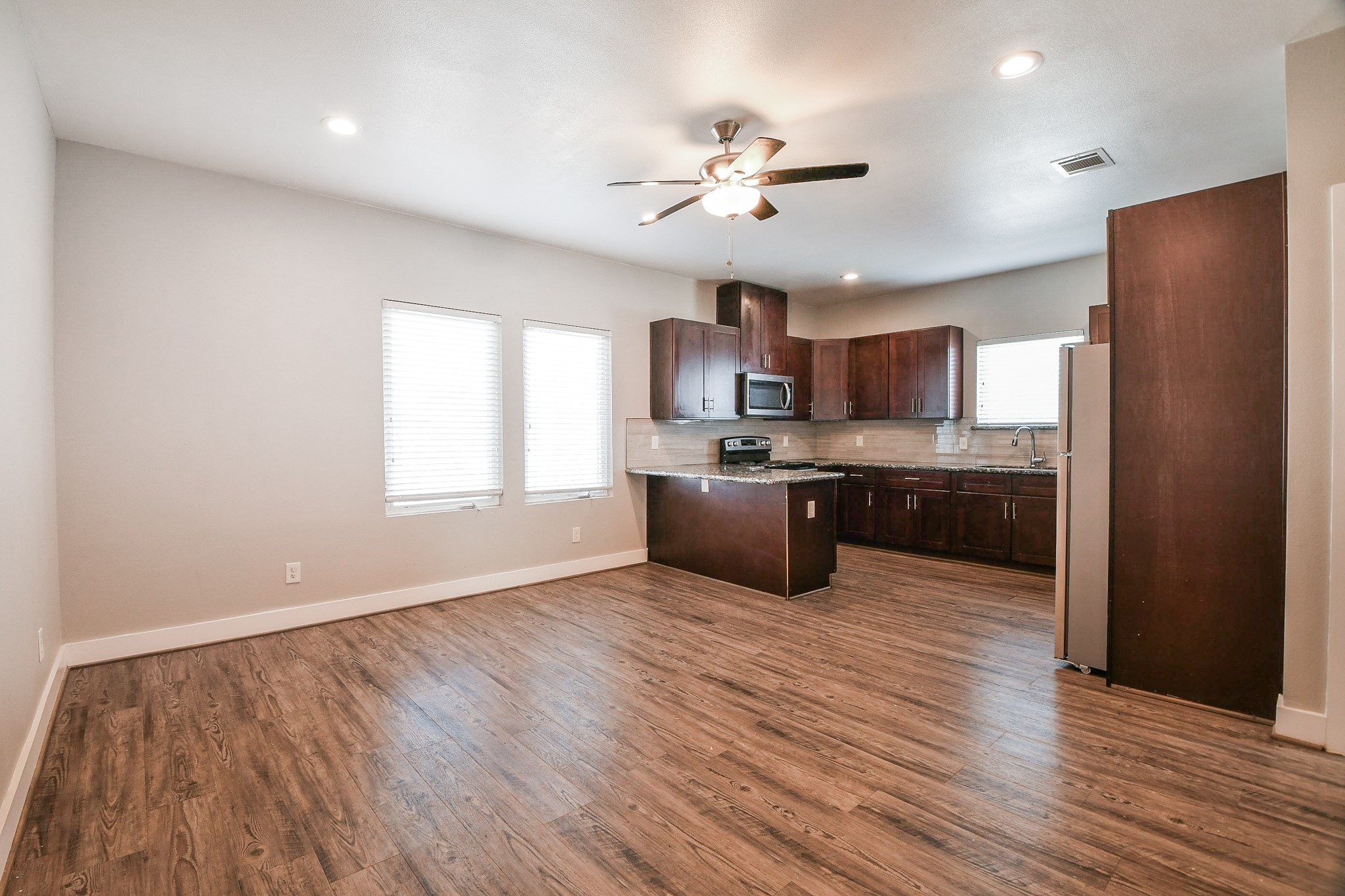 3249 Dixie Drive, Unit B Houston, TX 77021 - Photo 3 of 25 a large kitchen with stainless steel appliances granite countertop a stove a sink dishwasher a refrigerator and a wooden floor