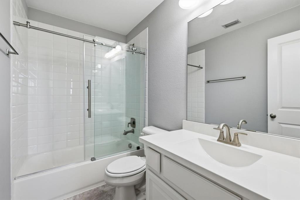 1933 Snapdragon Road Frisco, TX 75033 - Photo 32 of 40 Full bathroom featuring a white vanity with integrated sink, brushed nickel faucet, and frameless mirror
