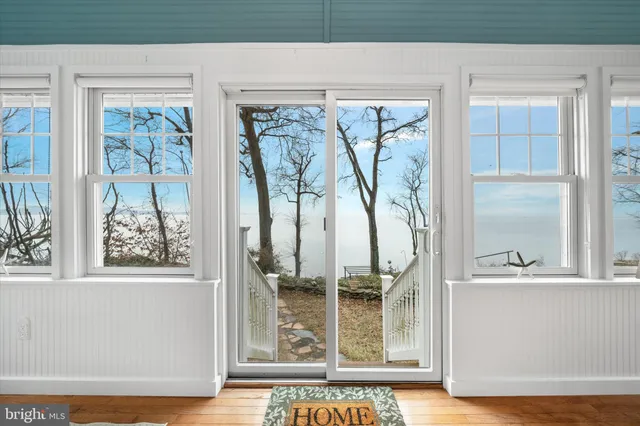 a dining room with wooden floor and windows