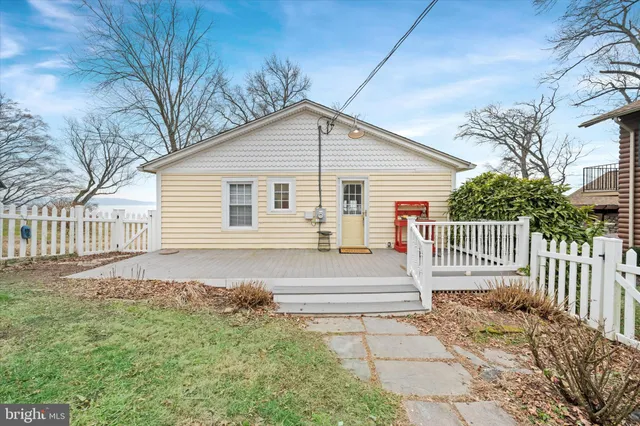 a view of a house with a small yard and wooden fence