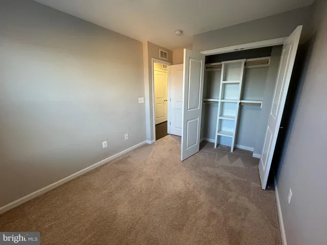 an empty room with ceiling fan and window