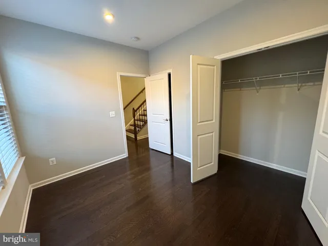 an empty room with wooden floor and closet