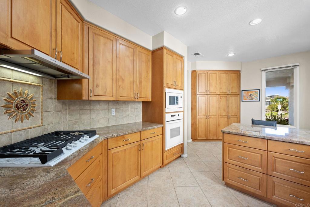 1827 Amalfi Drive Encinitas, CA 92024 - Photo 14 of 31 a kitchen with stainless steel appliances a stove a microwave and cabinets