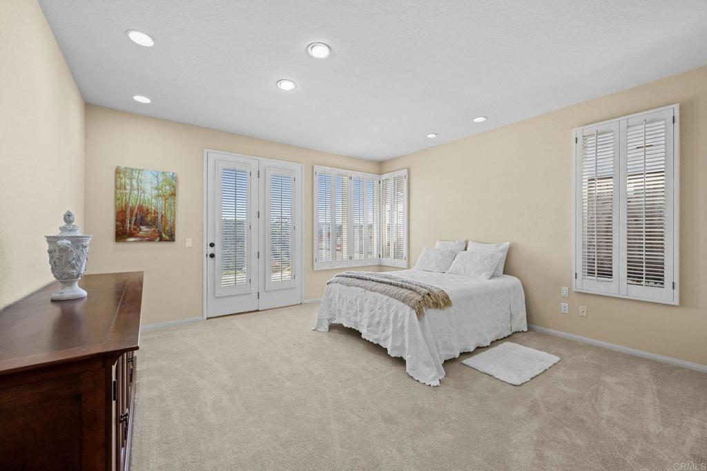 1827 Amalfi Drive Encinitas, CA 92024 - Photo 20 of 31 a spacious bedroom with a large bed and a desk
