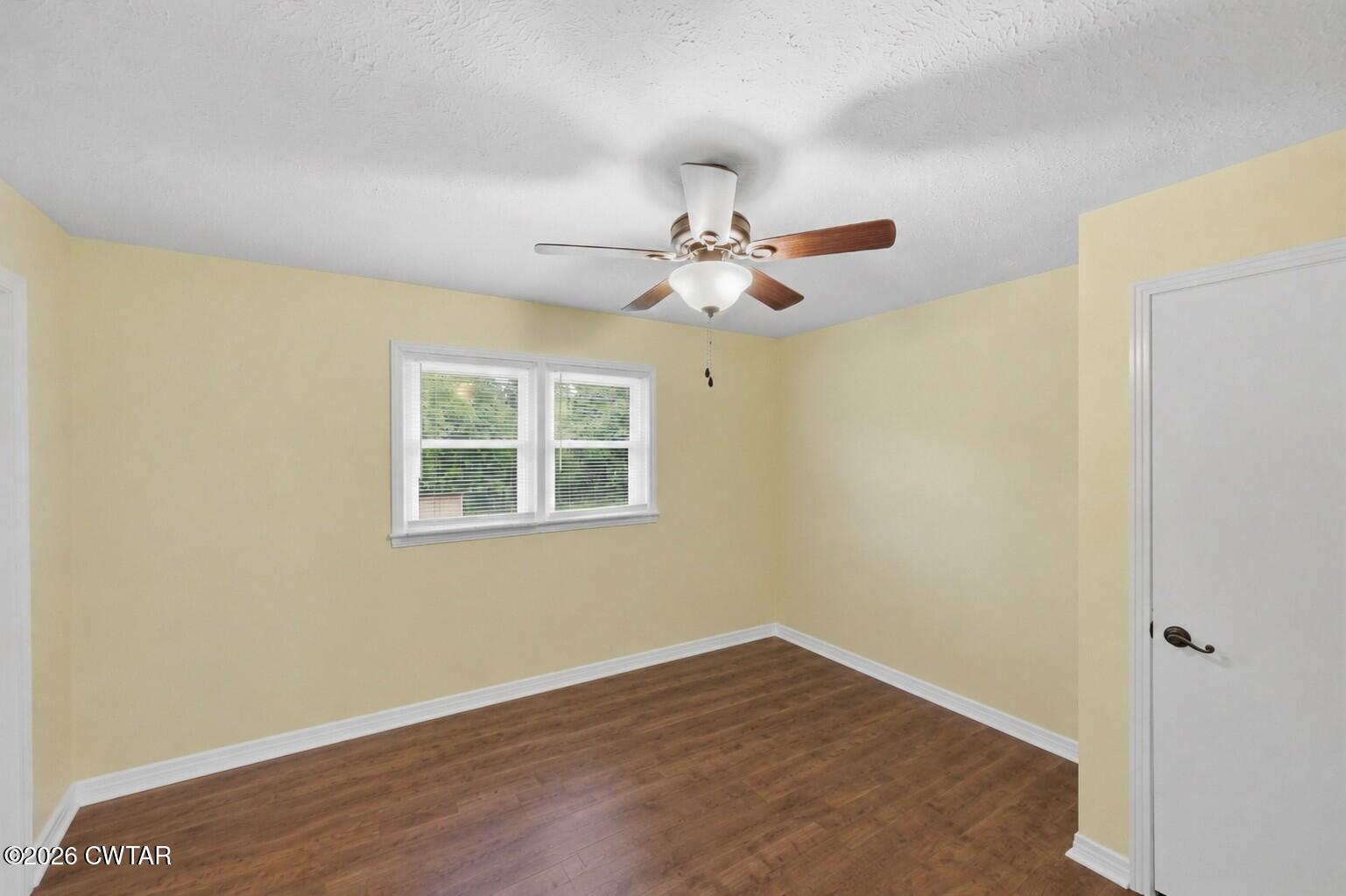944 Brooksie Thompson Road Decaturville, TN 38329 - Photo 27 of 47 a view of an empty room with wooden floor and a window