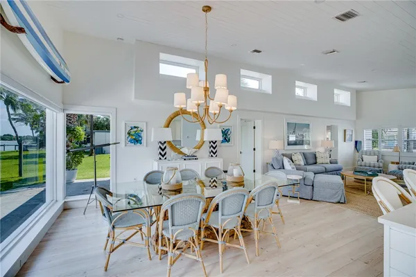 a view of a dining room and livingroom furniture wooden floor a rug and a chandelier