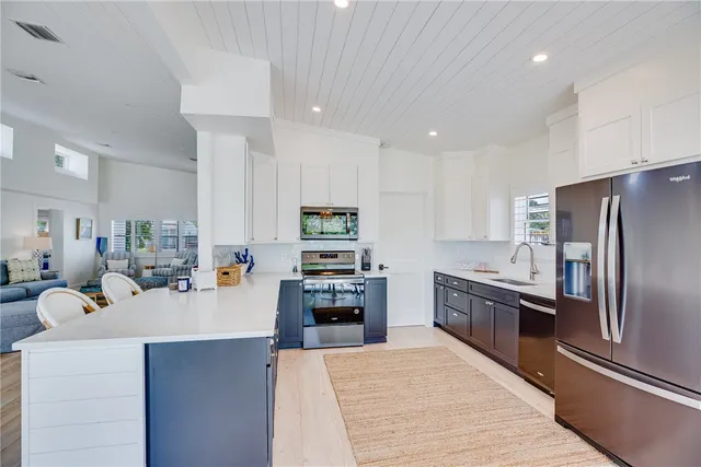 a large kitchen with stainless steel appliances and a refrigerator
