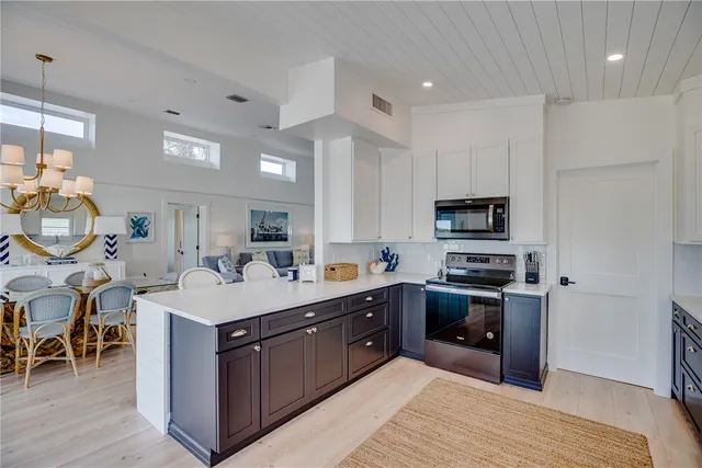 a large kitchen with stainless steel appliances a stove a sink a microwave and a refrigerator