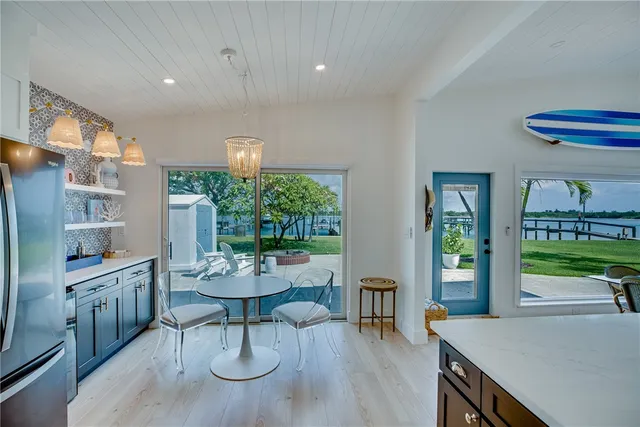a dining room with furniture a chandelier and wooden floor