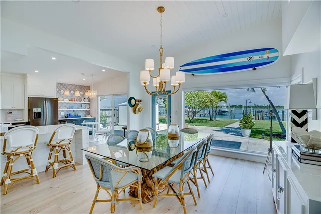 a dining room with furniture a chandelier and wooden floor