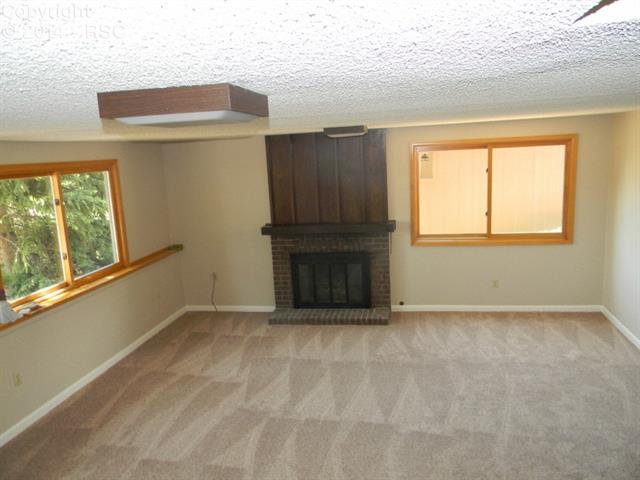 692 Gilcrest Road Colorado Springs, CO 80906 - Photo 5 of 25 Garden level family room with gas fireplace and lots of light