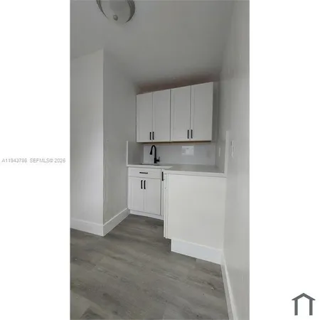 a kitchen with granite countertop white cabinets and white appliances