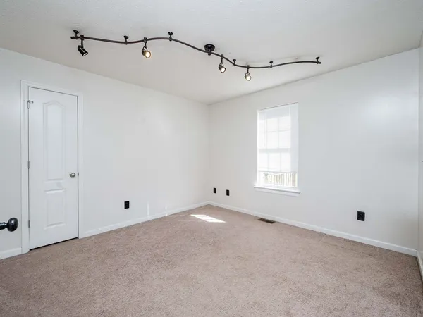 a bedroom with a large bed and a window