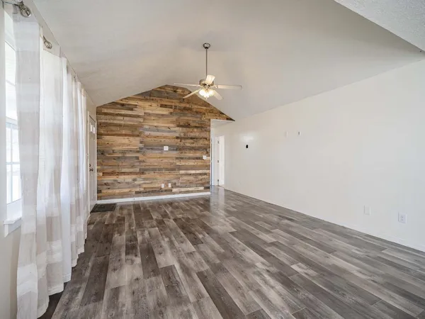 a view of empty room with wooden floor