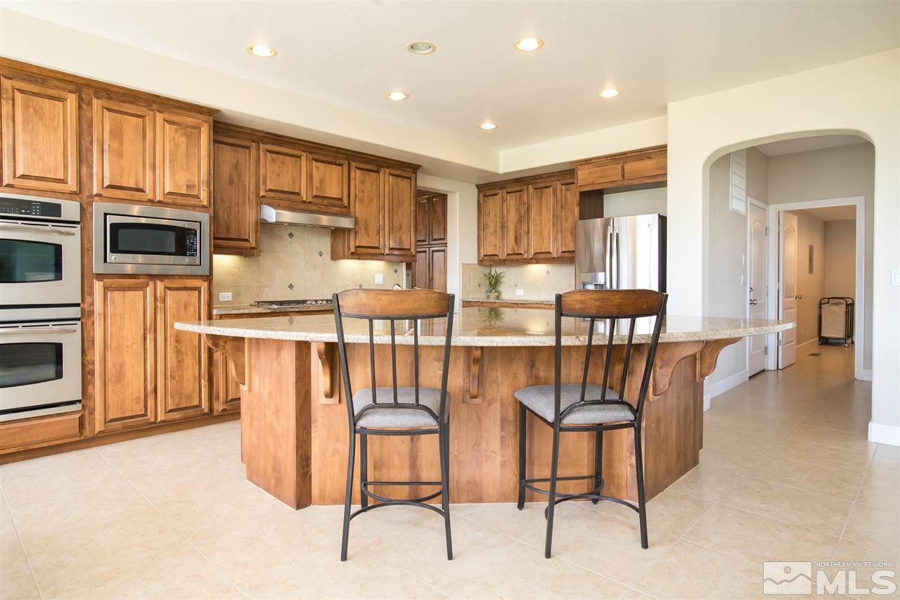8548 Timaru Trail Reno, NV 89523 - Photo 8 of 25 a kitchen with stainless steel appliances kitchen island granite countertop a refrigerator and wooden cabinets