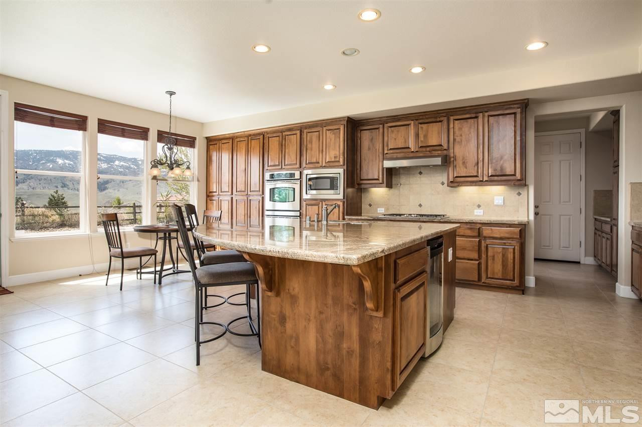 8548 Timaru Trail Reno, NV 89523 - Photo 9 of 25 a kitchen with kitchen island granite countertop a table chairs sink and cabinets