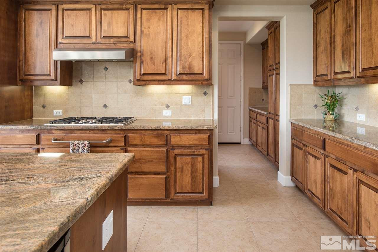 8548 Timaru Trail Reno, NV 89523 - Photo 10 of 25 a kitchen with stainless steel appliances granite countertop a stove a sink and a refrigerator