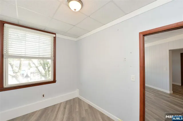 a view of hallway with window and wooden floor