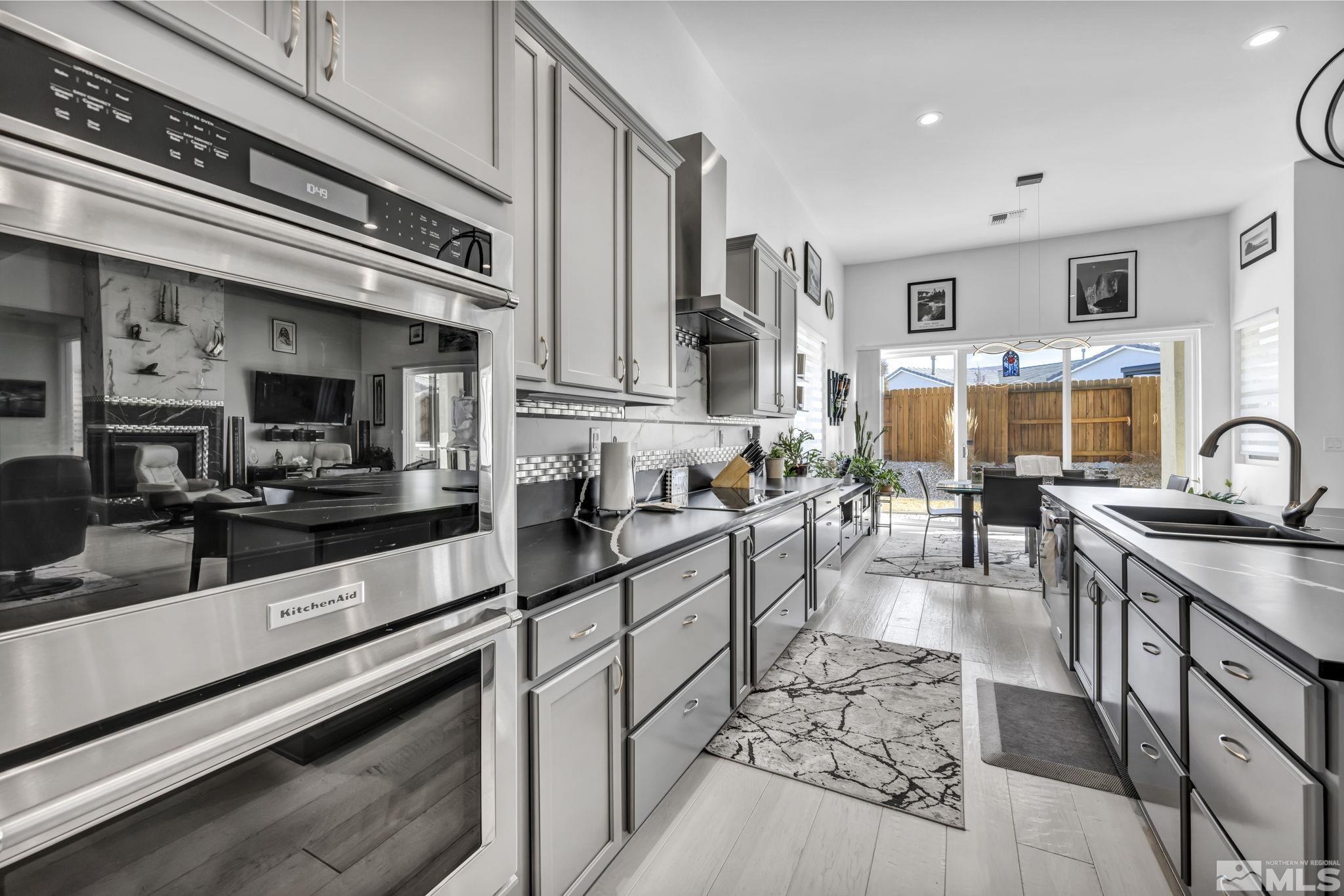 9500 Hawkshead Road Reno, NV 89521 - Photo 13 of 40 a kitchen with stainless steel appliances kitchen island granite countertop a sink and cabinets
