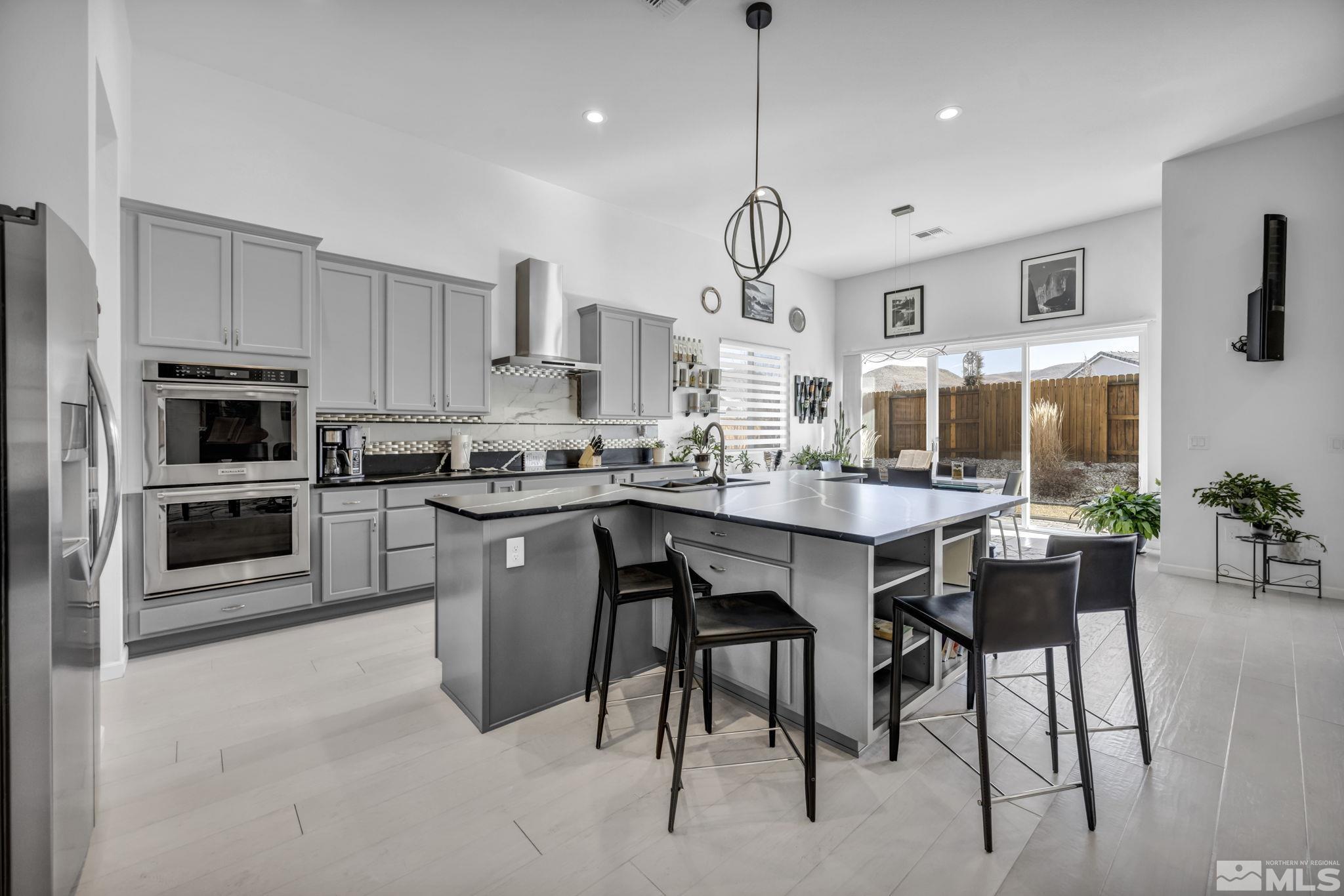 9500 Hawkshead Road Reno, NV 89521 - Photo 16 of 40 a kitchen with stainless steel appliances granite countertop a sink a stove a refrigerator cabinets and chairs