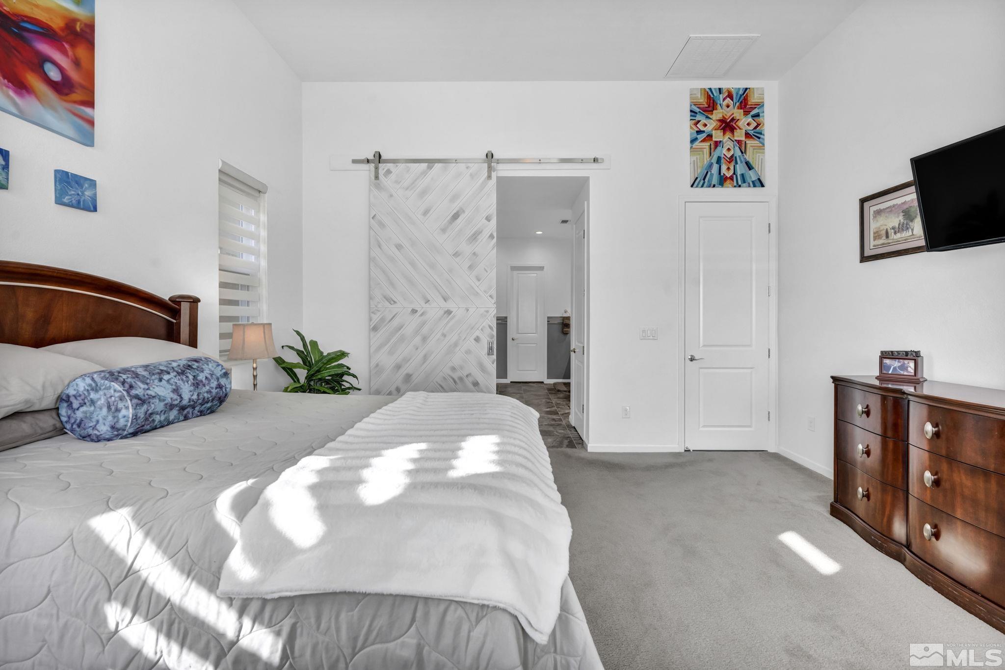 9500 Hawkshead Road Reno, NV 89521 - Photo 23 of 40 a spacious bedroom with a bed and a flat screen television