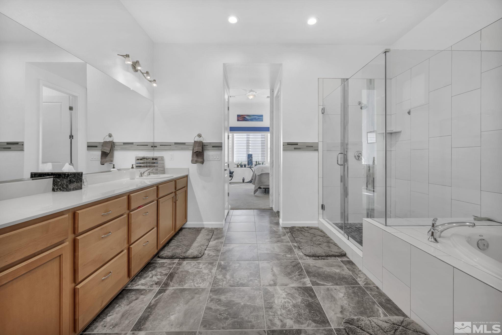 9500 Hawkshead Road Reno, NV 89521 - Photo 24 of 40 a large bathroom with a double vanity sink a large mirror and shower