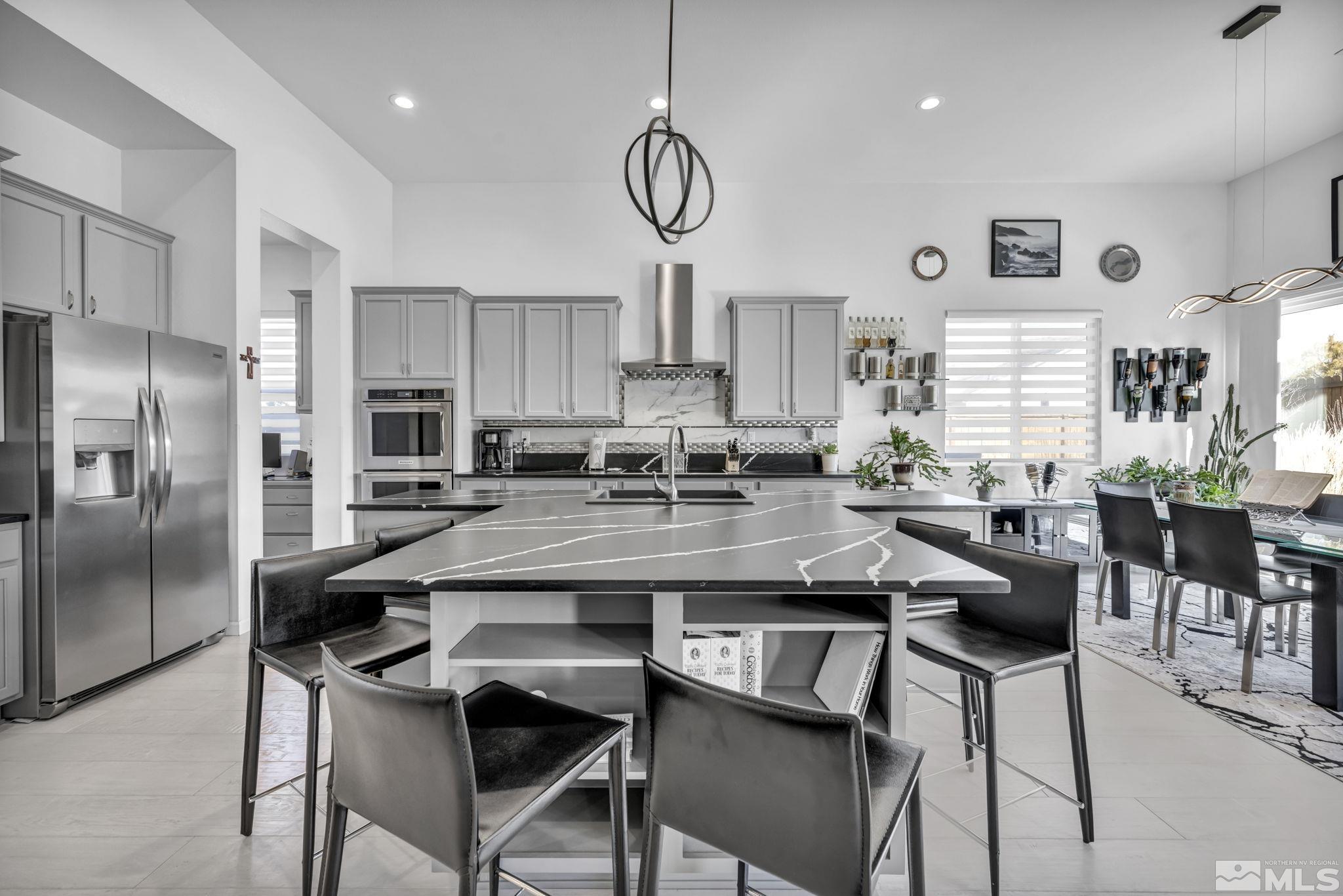 9500 Hawkshead Road Reno, NV 89521 - Photo 6 of 40 a kitchen with stainless steel appliances granite countertop a dining table chairs refrigerator and cabinets