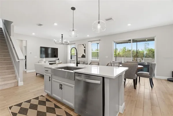 a kitchen with kitchen island granite countertop a sink appliances cabinets and furniture