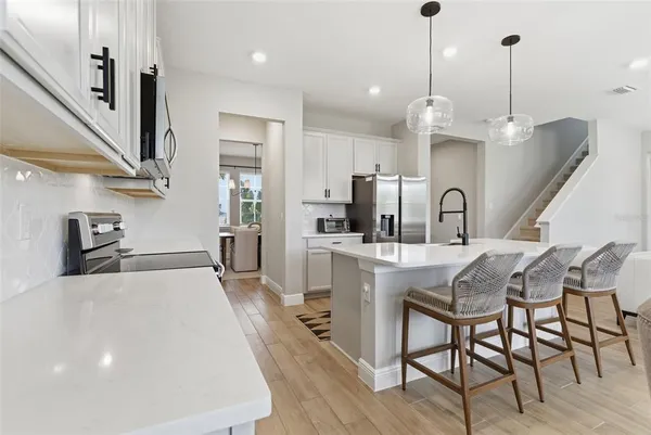 a kitchen with stainless steel appliances kitchen island a refrigerator sink and cabinets
