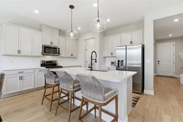 a kitchen with stainless steel appliances kitchen island granite countertop a sink and a stove