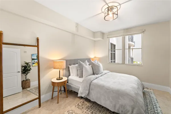 a bedroom with a bed and a potted plant