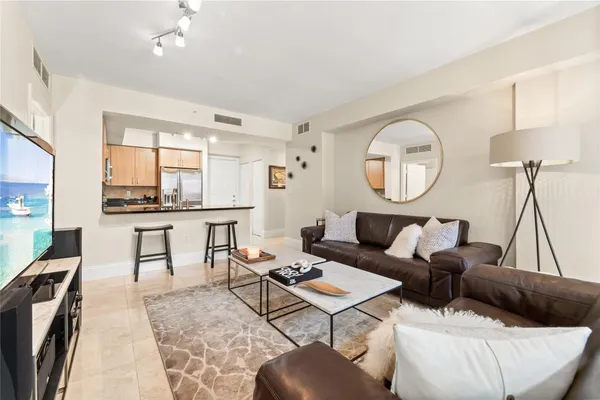 a living room with furniture a large window and wooden floor