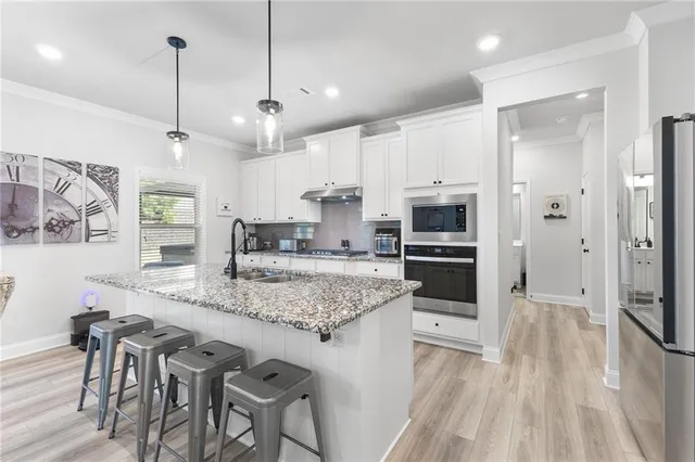a kitchen with stainless steel appliances granite countertop a stove refrigerator and cabinets
