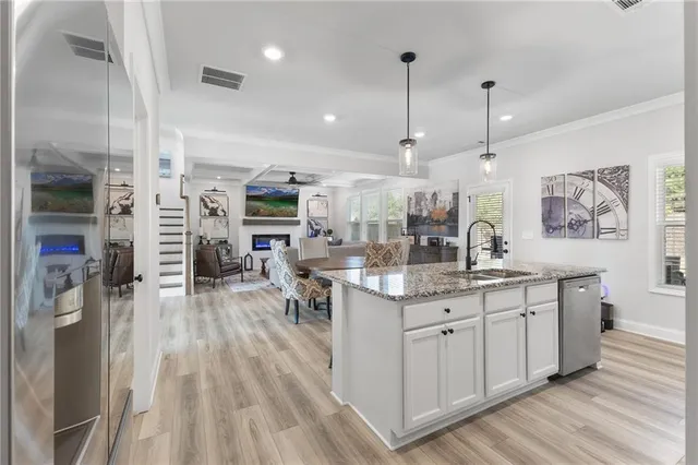 a kitchen with stainless steel appliances granite countertop a lot of counter space and wooden floors