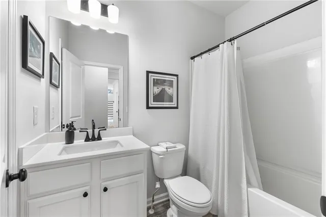 a bathroom with a sink a mirror a toilet and a shower