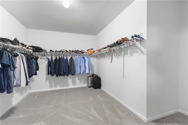a view of walk in closet with clothes and shoes