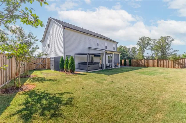 a view of a house with backyard and sitting area