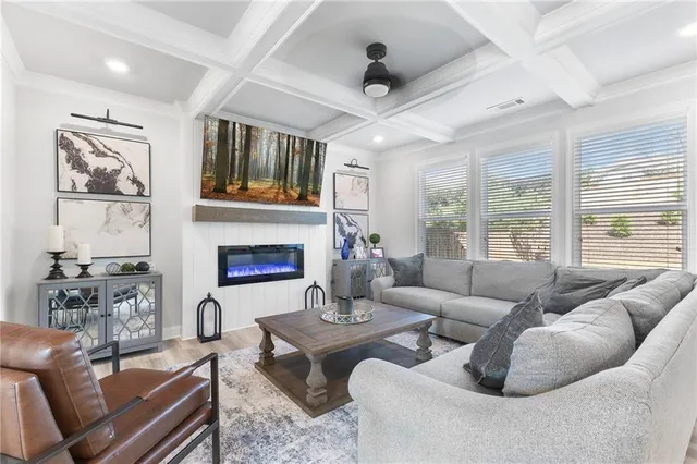 a living room with furniture fireplace and a large window