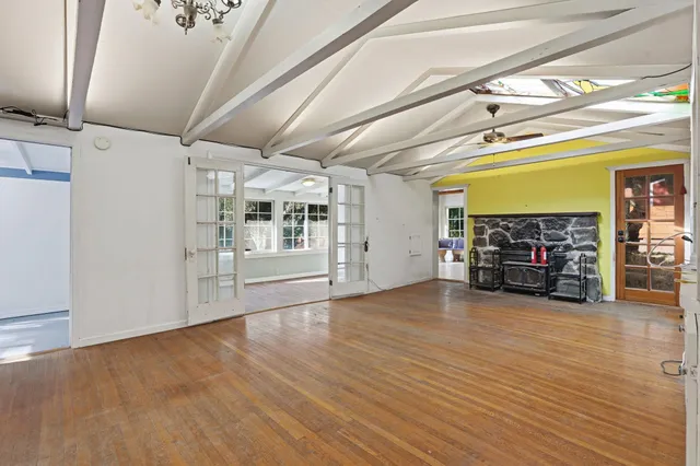 a view of an empty room with furniture and a window