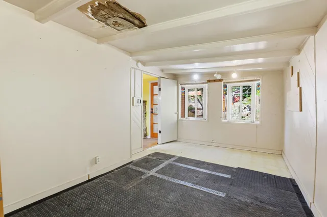 a view of an empty room with a balcony and window