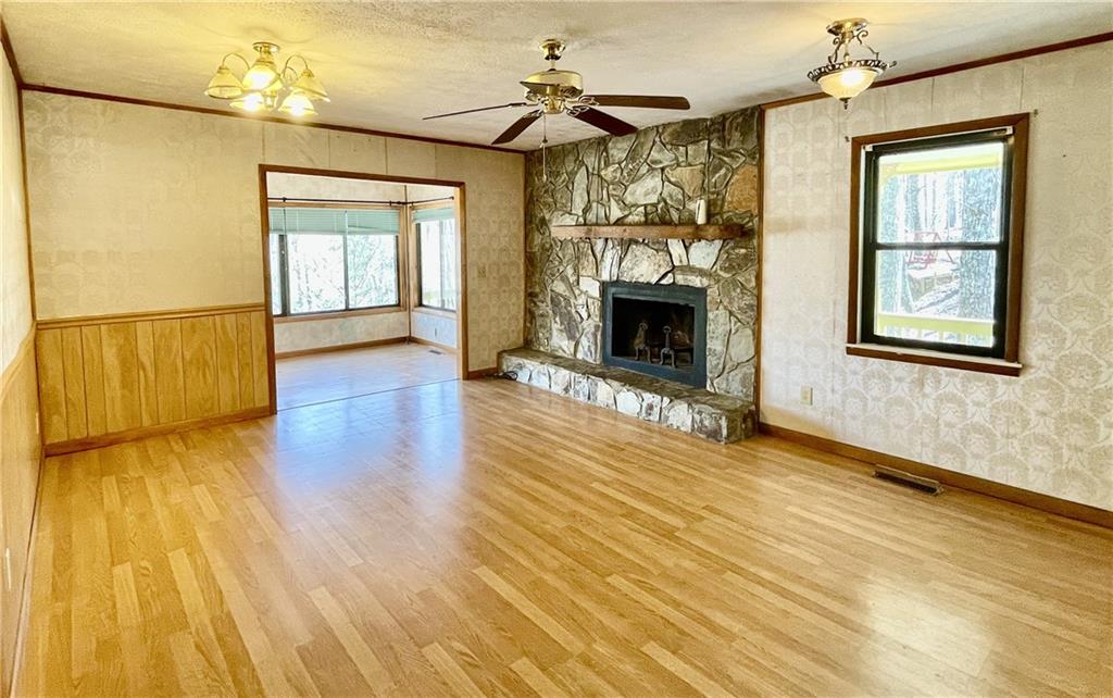 596 Ripshin Mountain Road Blue Ridge, GA 30513 - Photo 4 of 19 an empty room with wooden floor fireplace and windows