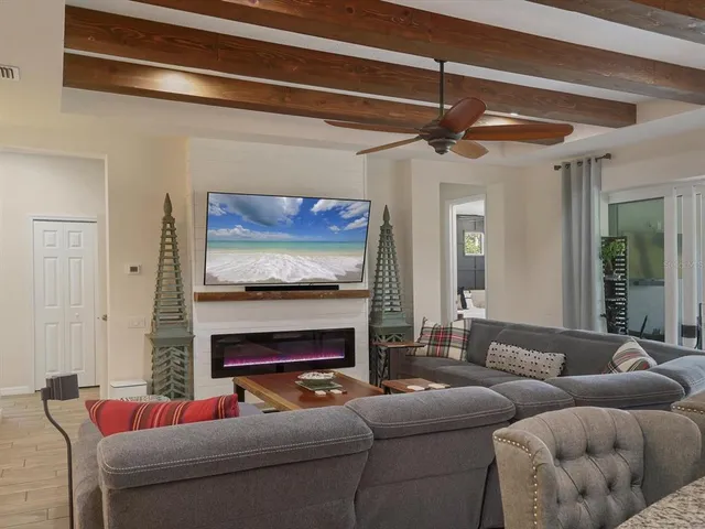 a living room with furniture kitchen view and a large window