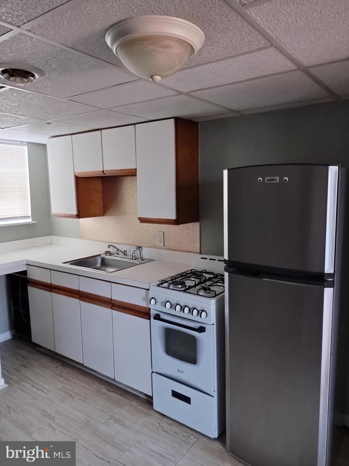 1112 Carpenter Street Philadelphia, PA 19147 - Photo 5 of 19 a kitchen with a stove a refrigerator and a sink