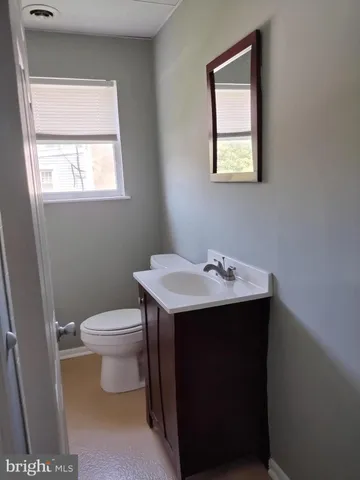 a bathroom with a sink toilet and window