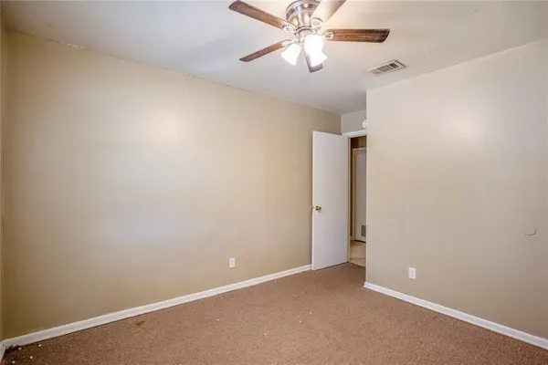 an empty room with a fan and a fan