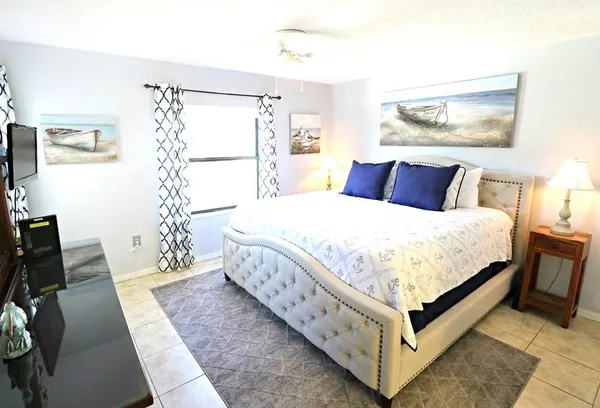 a large bedroom with a bed and a flat screen tv