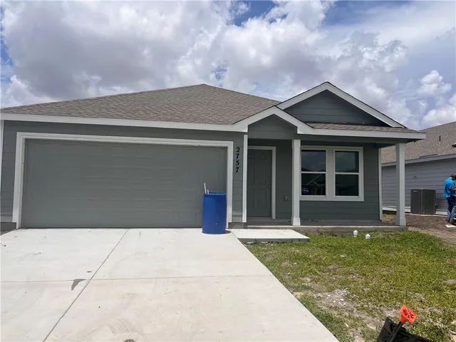 a front view of brick house with a yard