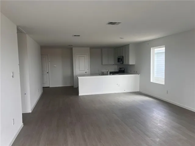a kitchen with a white cabinets and wooden floor